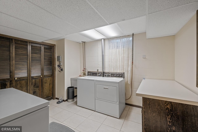 10425 Quaker Ln N, Maple Grove, MN 55369 - washroom with washing machine and dryer, light tile patterned floors, and concrete block wall