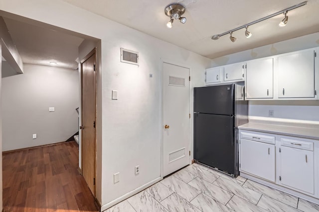 8932 Neill Lake Rd Unit 112B, Eden Prairie, MN 55347 - kitchen with freestanding refrigerator, white cabinetry, light countertops, and baseboards