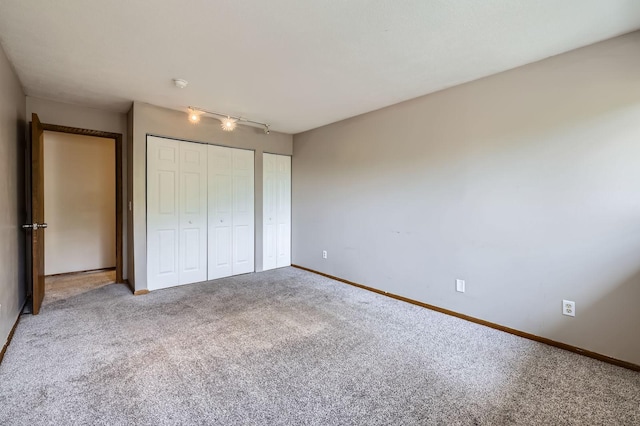 8932 Neill Lake Rd Unit 112B, Eden Prairie, MN 55347 - unfurnished bedroom featuring carpet floors, baseboards, track lighting, and multiple closets