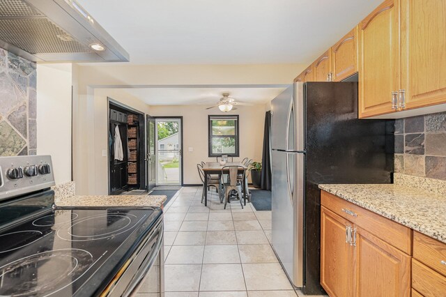4101 Welcome Ave N, Robbinsdale, MN 55422 - kitchen featuring appliances with stainless steel finishes, wall chimney exhaust hood, light stone counters, light tile patterned floors, and ceiling fan