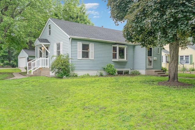 4101 Welcome Ave N, Robbinsdale, MN 55422 - view of front of home with an outbuilding, a shingled roof, a front lawn, and a detached garage