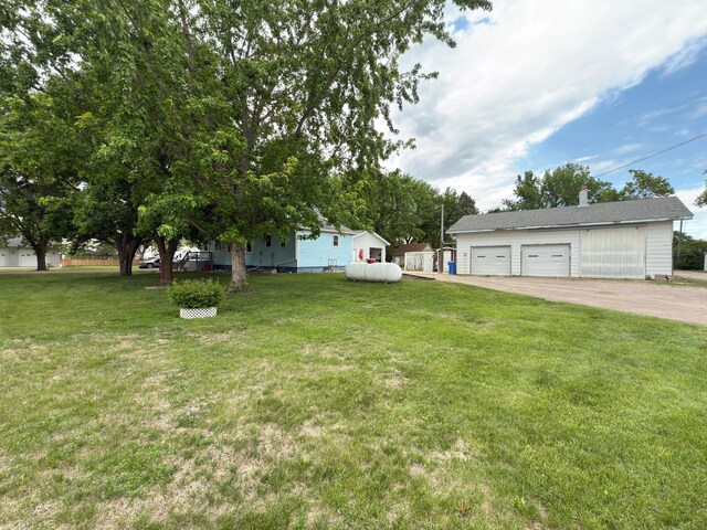 107 3rd Ave, Bellingham, MN 56212 - view of green lawn with a detached garage and an outdoor structure