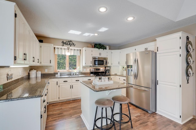 2301 170th Ln NW, Andover, MN 55304 - kitchen featuring stainless steel appliances, a sink, light wood finished floors, dark stone counters, and recessed lighting