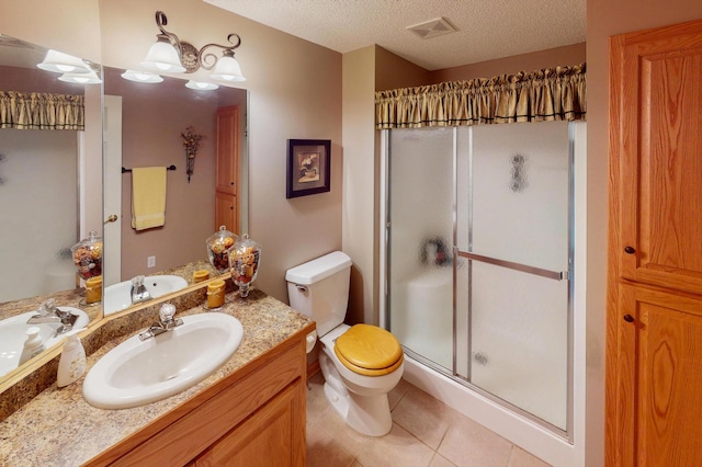 2301 170th Ln NW, Andover, MN 55304 - bathroom featuring a stall shower, vanity, toilet, a textured ceiling, and tile patterned floors