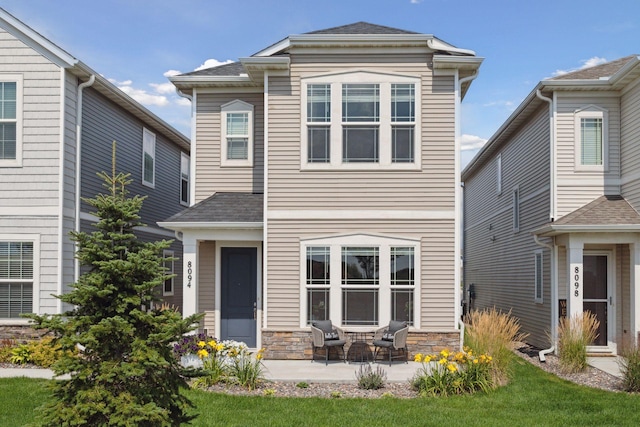 8094 Arrowwood Ln N, Maple Grove, MN 55369 - view of front of home with a patio, roof with shingles, and stone siding