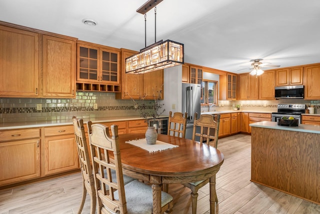674 Mound Ave, Shoreview, MN 55126 - kitchen featuring appliances with stainless steel finishes, backsplash, light wood finished floors, and light countertops