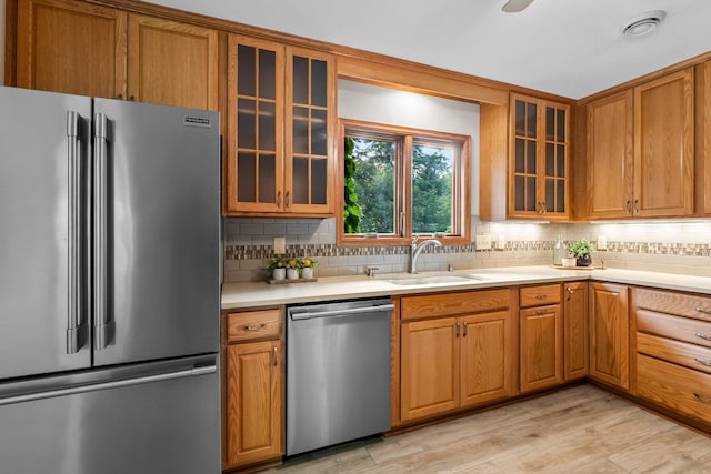 674 Mound Ave, Shoreview, MN 55126 - kitchen featuring appliances with stainless steel finishes, light countertops, decorative backsplash, and brown cabinetry
