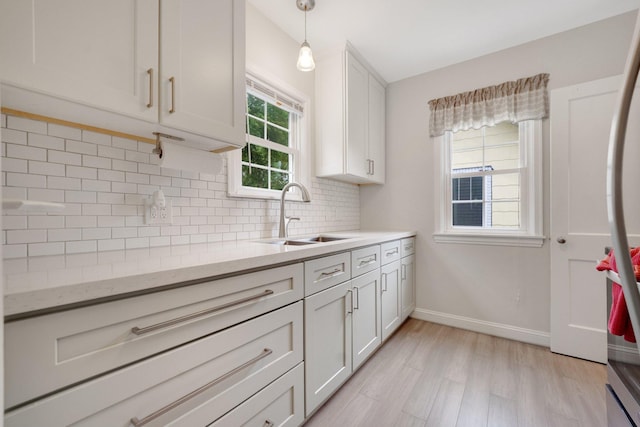 3243 Cleveland St NE, Minneapolis, MN 55418 - kitchen with a sink, light wood-style flooring, backsplash, freestanding refrigerator, and baseboards