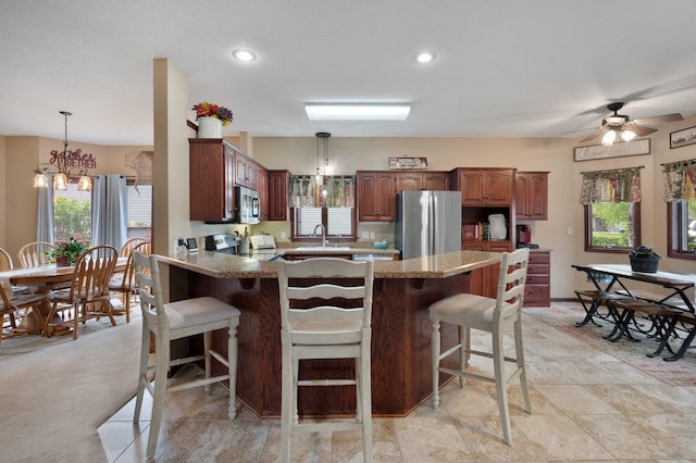 145 Bluebird Ln, Clearwater, MN 55320 - kitchen featuring stainless steel appliances, a sink, a peninsula, a breakfast bar area, and a chandelier