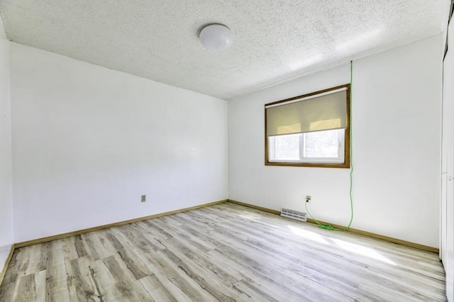 9705 99th Ave N, Maple Grove, MN 55369 - spare room featuring wood finished floors, a textured ceiling, and baseboards