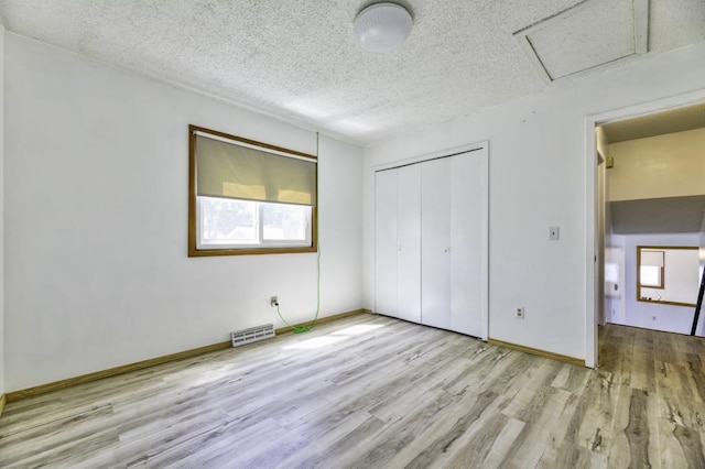 9705 99th Ave N, Maple Grove, MN 55369 - unfurnished bedroom with wood finished floors, multiple windows, a closet, a textured ceiling, and attic access