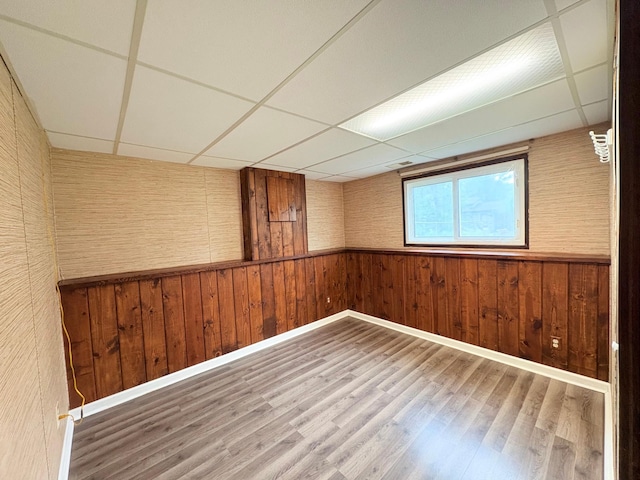 9705 99th Ave N, Maple Grove, MN 55369 - spare room with a paneled ceiling, wooden walls, wood finished floors, and a wainscoted wall