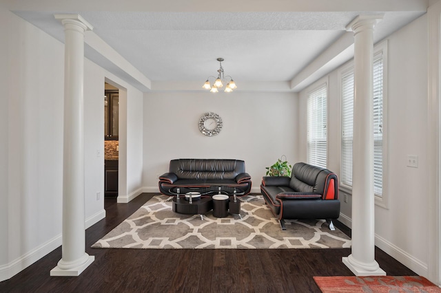 18301 100th Ave N, Osseo, MN 55311 - sitting room featuring dark wood-style flooring, baseboards, ornate columns, a tray ceiling, and a chandelier