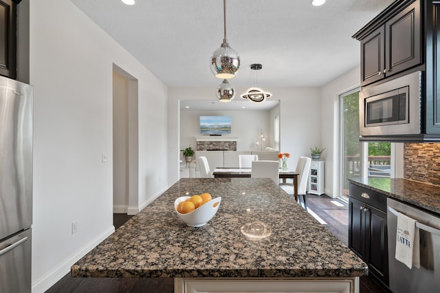 18301 100th Ave N, Osseo, MN 55311 - kitchen with appliances with stainless steel finishes, dark stone counters, baseboards, dark wood-style floors, and backsplash