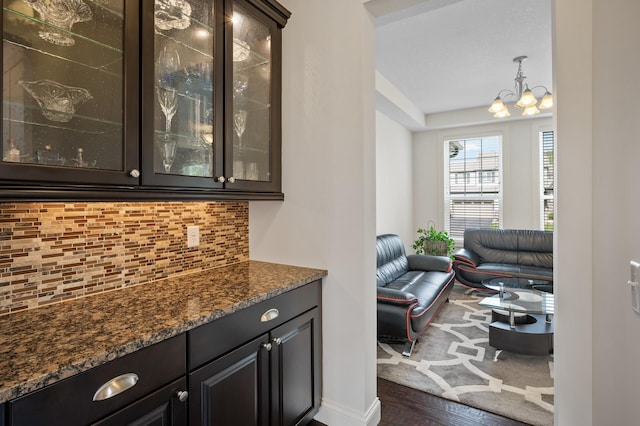 18301 100th Ave N, Osseo, MN 55311 - bar area featuring decorative backsplash, a chandelier, dark wood finished floors, and baseboards