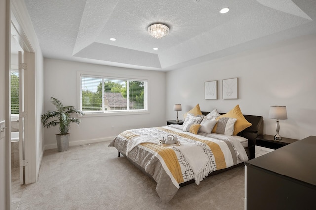 18301 100th Ave N, Osseo, MN 55311 - bedroom featuring a textured ceiling, light colored carpet, a tray ceiling, and baseboards