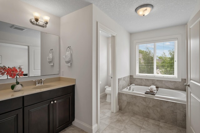 18301 100th Ave N, Osseo, MN 55311 - full bathroom with a garden tub, vanity, toilet, a textured ceiling, and tile patterned floors
