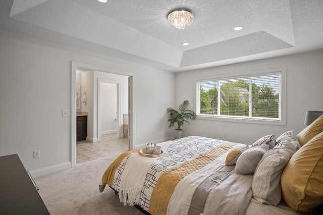 18301 100th Ave N, Osseo, MN 55311 - bedroom featuring a tray ceiling, a textured ceiling, baseboards, light colored carpet, and ensuite bath