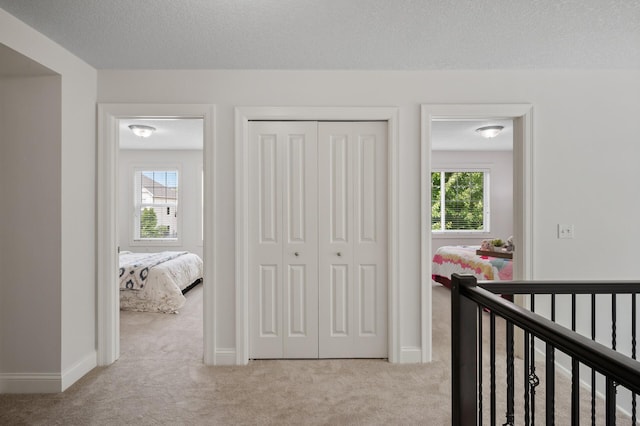 18301 100th Ave N, Osseo, MN 55311 - carpeted bedroom featuring multiple windows, a closet, baseboards, and a textured ceiling