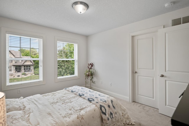 18301 100th Ave N, Osseo, MN 55311 - bedroom featuring light colored carpet, a textured ceiling, and baseboards