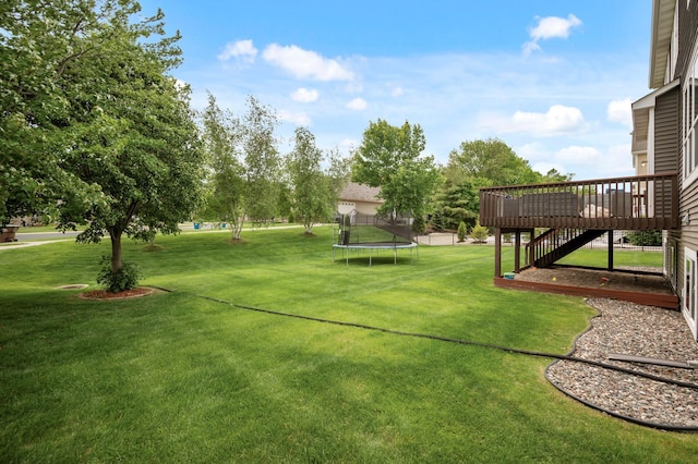 18301 100th Ave N, Osseo, MN 55311 - view of grassy yard with a trampoline, a wooden deck, and stairway