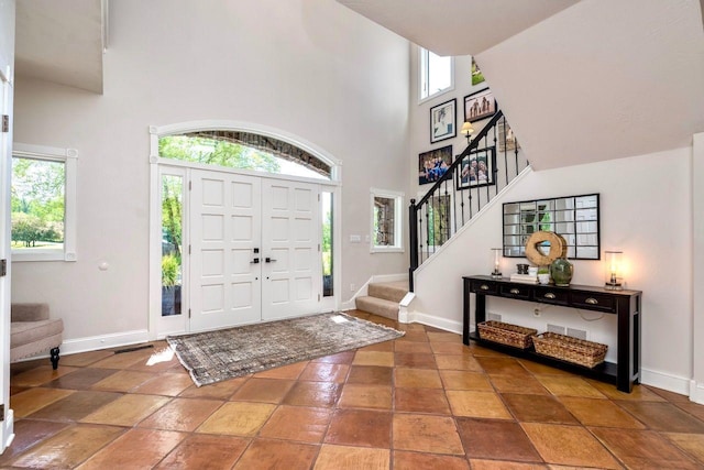 24534 474th Ln, Elysian Twp, MN 56028 - entrance foyer featuring healthy amount of natural light, stairs, a high ceiling, and baseboards