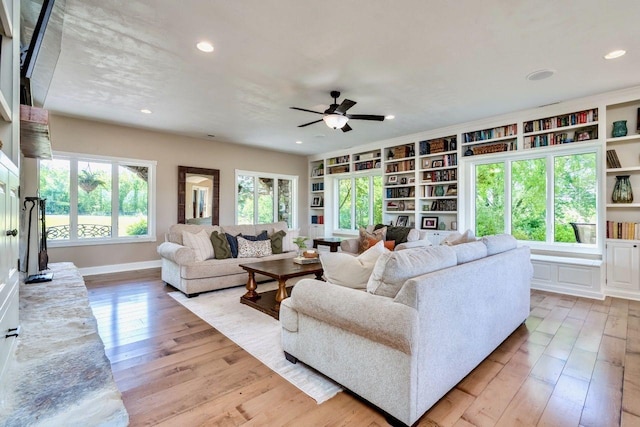 24534 474th Ln, Elysian Twp, MN 56028 - living area featuring light wood finished floors, a ceiling fan, baseboards, recessed lighting, and built in shelves