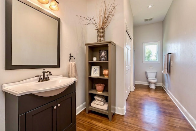 24534 474th Ln, Elysian Twp, MN 56028 - bathroom with vanity, wood finished floors, toilet, and baseboards