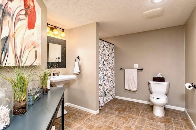 24534 474th Ln, Elysian Twp, MN 56028 - full bath with stone finish flooring, toilet, baseboards, a shower with shower curtain, and a textured ceiling