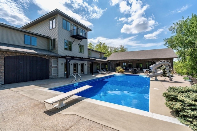24534 474th Ln, Elysian Twp, MN 56028 - outdoor pool featuring a water slide, a diving board, and a patio