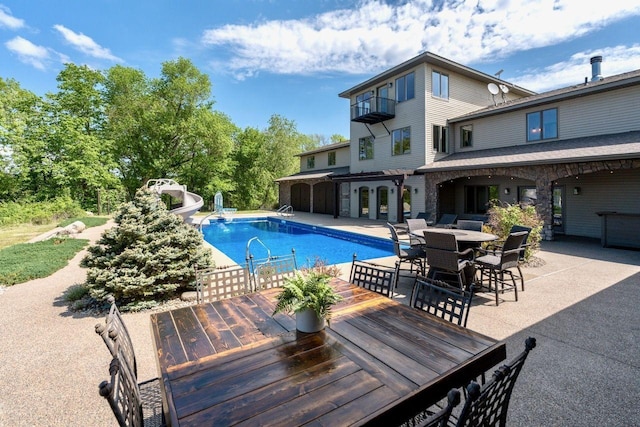 24534 474th Ln, Elysian Twp, MN 56028 - outdoor pool featuring a water slide, outdoor dining space, and a patio