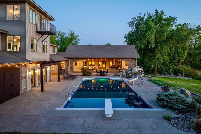24534 474th Ln, Elysian Twp, MN 56028 - outdoor pool with a water slide, a diving board, and a patio