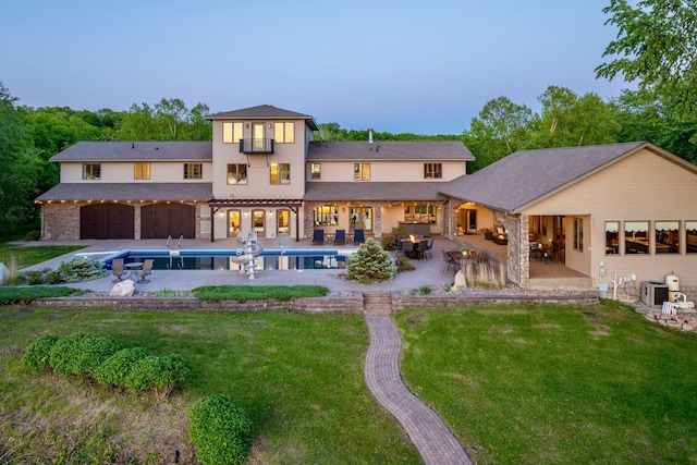 24534 474th Ln, Elysian Twp, MN 56028 - back of property at dusk with a patio area, a yard, and an outdoor pool