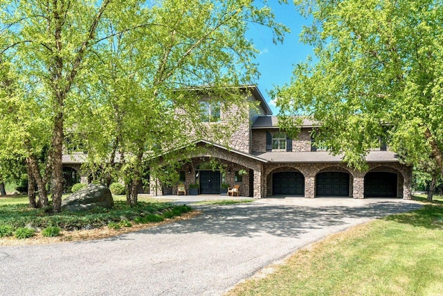 24534 474th Ln, Elysian Twp, MN 56028 - view of front of property featuring driveway, an attached garage, and stone siding