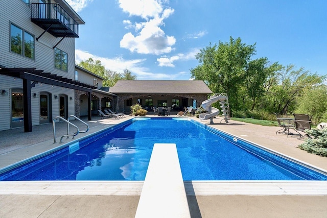 24534 474th Ln, Elysian Twp, MN 56028 - swimming pool featuring a patio, a diving board, and a water slide