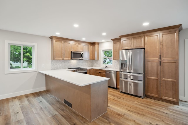 3936 Quail Ave N, Robbinsdale, MN 55422 - kitchen with stainless steel appliances, a peninsula, tasteful backsplash, a sink, and light countertops