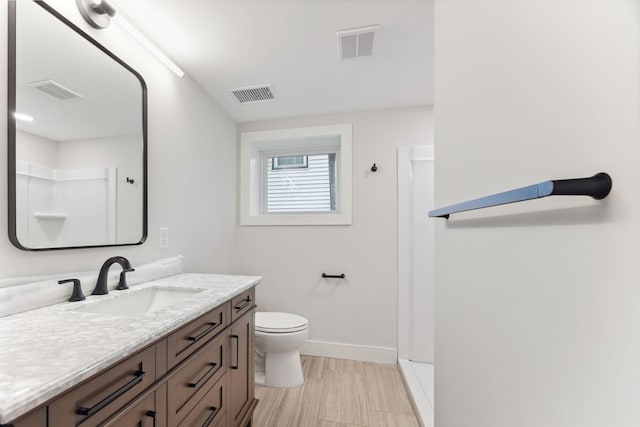 3936 Quail Ave N, Robbinsdale, MN 55422 - bathroom with vanity, baseboards, toilet, and a shower