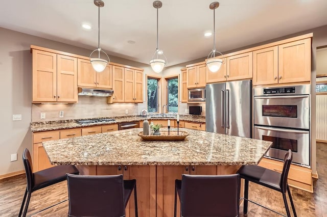 946 Wild Rose Ct, Eagan, MN 55123 - kitchen featuring stainless steel appliances, light brown cabinets, light stone countertops, a kitchen bar, and recessed lighting