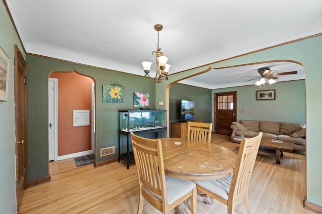 967 Stryker Ave W, Saint Paul, MN 55118 - dining room with arched walkways, light wood-type flooring, a ceiling fan, and crown molding