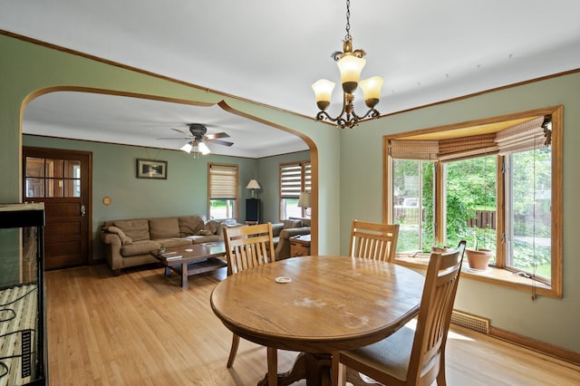 967 Stryker Ave W, Saint Paul, MN 55118 - dining area with arched walkways, light wood-type flooring, healthy amount of natural light, a chandelier, and ornamental molding