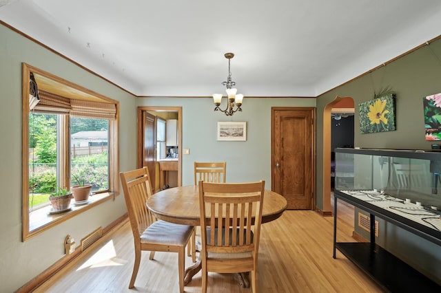 967 Stryker Ave W, Saint Paul, MN 55118 - dining room featuring light wood-style flooring, arched walkways, and a chandelier