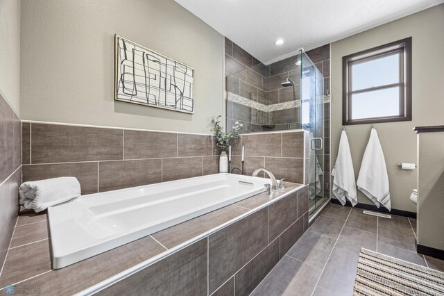2800 Mcleod Dr E, West Fargo, ND 58078 - bathroom featuring a bath, a shower stall, tile patterned floors, and baseboards