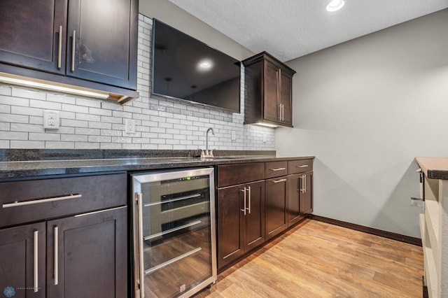 2800 Mcleod Dr E, West Fargo, ND 58078 - kitchen with wine cooler, backsplash, light wood finished floors, dark brown cabinetry, and a sink