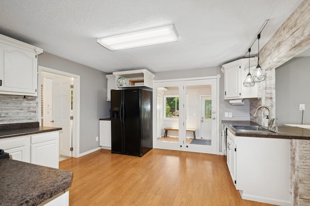 6198 210th Ave SE, Lake Lillian Twp, MN 56253 - kitchen with black fridge, dark countertops, a sink, light wood-type flooring, and a textured ceiling