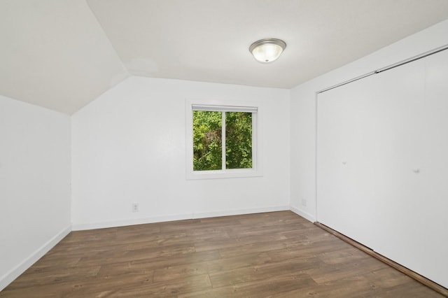 6198 210th Ave SE, Lake Lillian Twp, MN 56253 - unfurnished bedroom with wood finished floors, lofted ceiling, a closet, and baseboards
