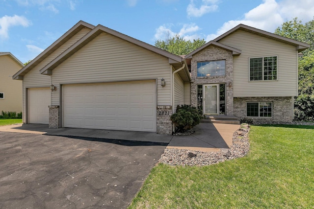 2821 15th Ave S, Saint Cloud, MN 56301 - view of front of property featuring a garage, brick siding, a front yard, and driveway