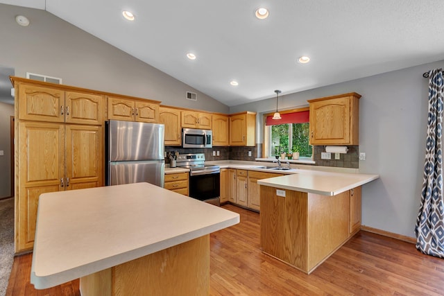 2821 15th Ave S, Saint Cloud, MN 56301 - kitchen with appliances with stainless steel finishes, vaulted ceiling, a peninsula, backsplash, and light wood-type flooring