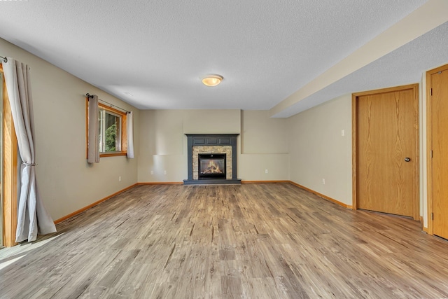 2821 15th Ave S, Saint Cloud, MN 56301 - unfurnished living room featuring a textured ceiling, light wood finished floors, baseboards, and a fireplace