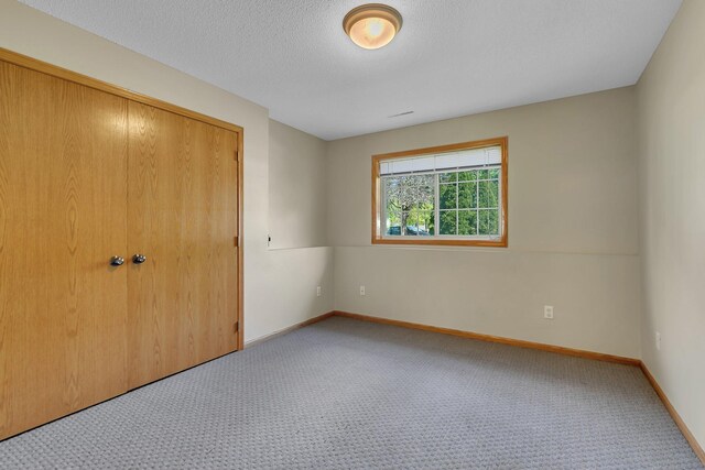 2821 15th Ave S, Saint Cloud, MN 56301 - unfurnished bedroom with carpet flooring, a closet, baseboards, and a textured ceiling