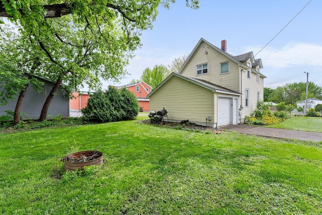 208 2nd St SW, Braham, MN 55006 - view of side of property featuring a chimney, a lawn, an attached garage, and asphalt driveway